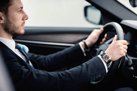 Successful Businessman. Confident young chief executive driving alone in luxury car, side view