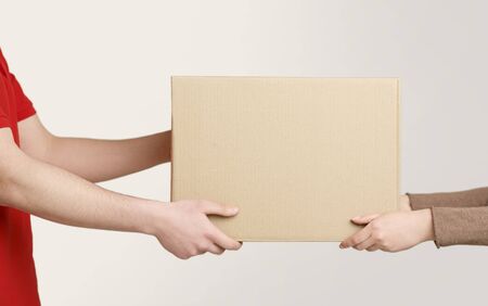 Woman hands accepting delivery of box from deliveryman, cropped, close up, free spaceの写真素材