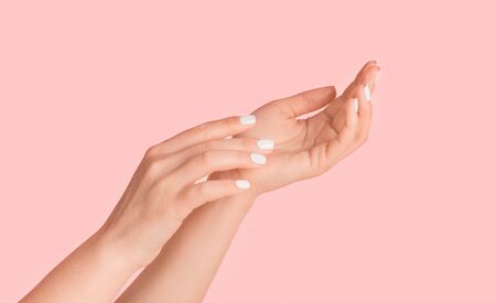 Young woman showing hands with silky skin and perfect manicure on pink background, closeup. Panoramaの写真素材