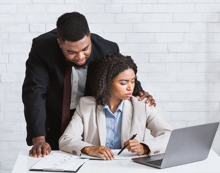 No to sexual harassment. Boss touching his young attractive female assistant in company officeの写真素材