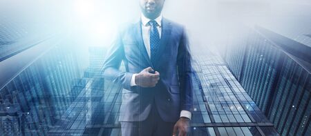 Business in big cities concept. Double exposure of African American businessman and skyscrapers, collage. Panoramaの写真素材