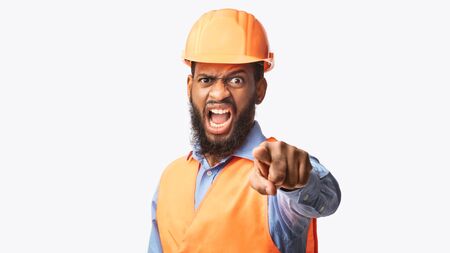 Building Career. Mad Black Builder Guy Shouting Pointing Finger At Camera Over White Studio Background. Panoramaの写真素材