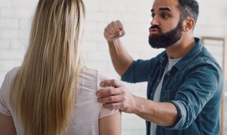 Violence and psychological problems in family. Angry man swings fist at woman, croppedの写真素材