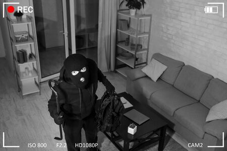 Being Caught. Robber entering house, holding crowbar and looking at CCTV camera, high angle view...