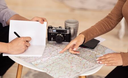 Travel Plan. Unrecognizable Spouses Pointing Fingers At Map Choosing Vacation Destination Sitting At...