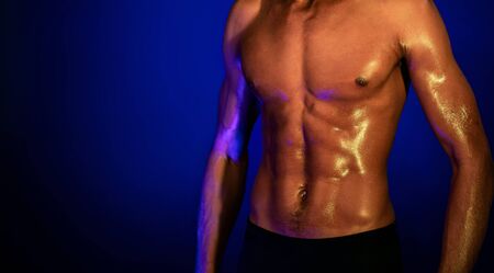 Muscular African Man With Perfect Abs Posing In Studio On Blue Background. Cropped, Panorama, Free Space For Textの写真素材