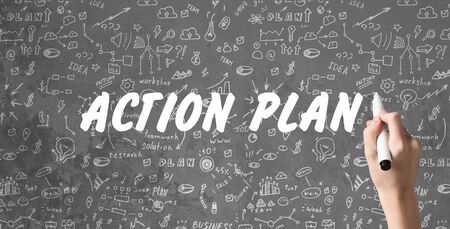 Strategy Concept. The Action Plan written on gray background with illustrations and drawings, hand holding markerの写真素材