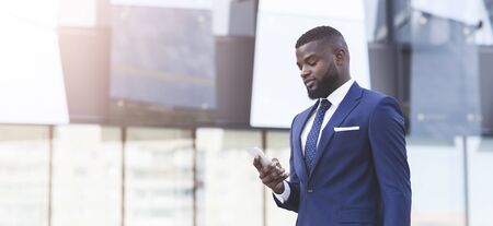 Business Lifestyle Concept. Businessman Using Smartphone With Business Application Walking In Urban...