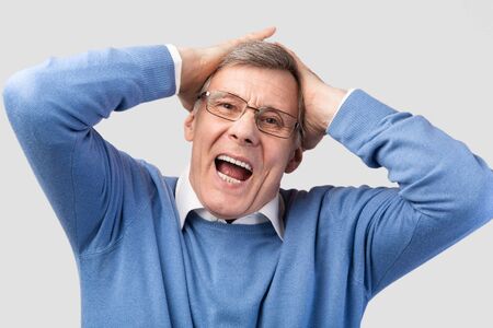 Emotional Senior Man Shouting Touching Head Posing On Gray Studio Background. Oh, No Concept
