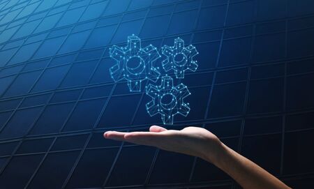 Efficiency in business. Male hand holding polygonal gears on dark blue background, collage. Panorama