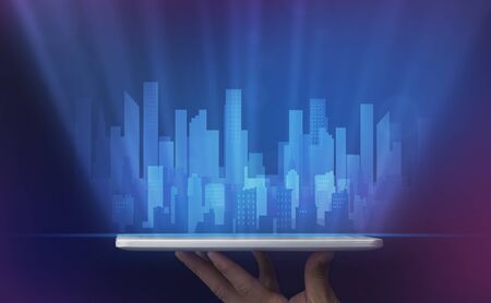 Hand Holding Digital Tablet With Holographic City Highrise Buildings On Blue Background. Smart Town, IoT Concept. Croppedの写真素材