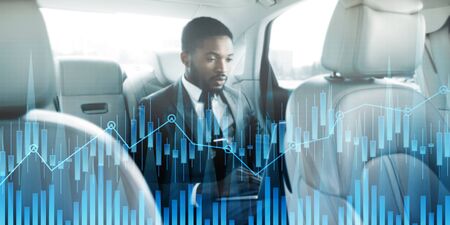African American entrepreneur working with laptop computer inside his car, creative collage with financial graphs. Panoramaの写真素材