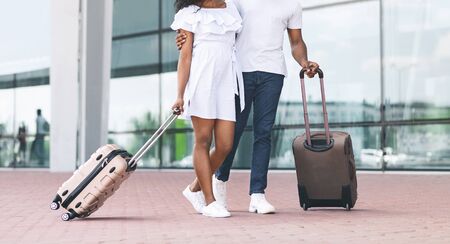 Unrecognizable Black Couple Walking With Suitcases Outdoors After Arriving To Airport, Going To Terminalの写真素材