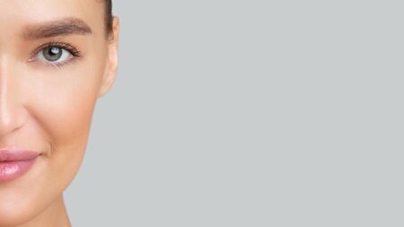 Half-face portrait of young beautiful woman with perfect skin, closeup, empty space for logo or text...