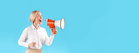Woman in office wear shouting into megaphone on blue background, space for text. Panoramaの写真素材