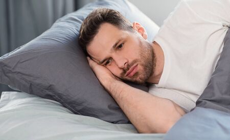 Male Depression Concept. Apathetic Man Having Insomnia Thinking About Problems Lying In Bed At Home....