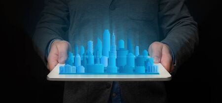 Unrecognizable Architect Holding Tablet With Modern City Holographic Model Standing On Black...