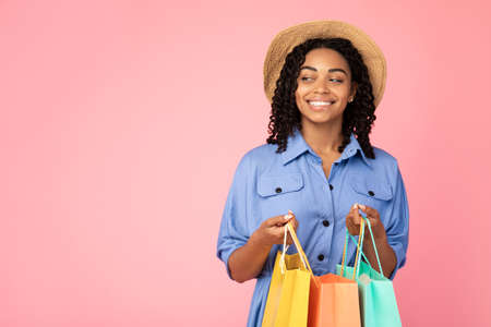 Summer Sales. Black Girl With Shopping Bags Standing Posing Over Pink Background. Studio Shot, Empty Spaceの写真素材
