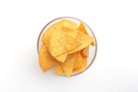 Crispy food for evening. Glass bowl with nachos isolated on white background, free spaceの写真素材