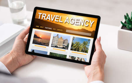 Online Travel Agency Website Opened On Digital Tablet In Female Hands, Closeupの写真素材