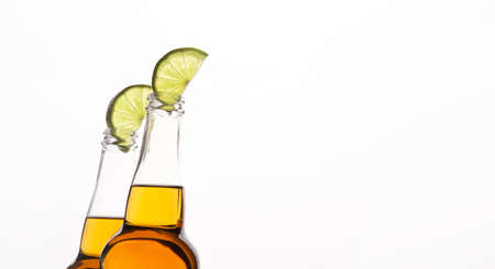 Transparent beer bottles with light drink with lime slices, cropped, isolated on white background, panorama, free spaceの写真素材