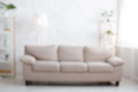 Cozy living room. Blurred photo of sofa, in light interior with window, flat lay, copy space