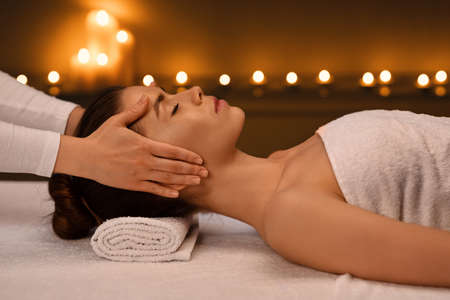Young woman getting healing head massage at modern luxury spa, side viewの写真素材