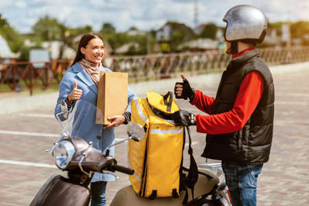 Great Delivery Service. Courier Guy And Customer Girl Gesturing Thumbs Up Standing Near Scooter...