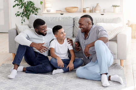 Good Time With Family. Preteen Black Boy Bonding With Dad And Grandfather At Homeの写真素材