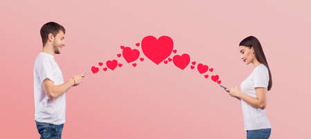 Love Concept. Beautiful couple chatting, creative collage with hearts connecting two smart phones,...