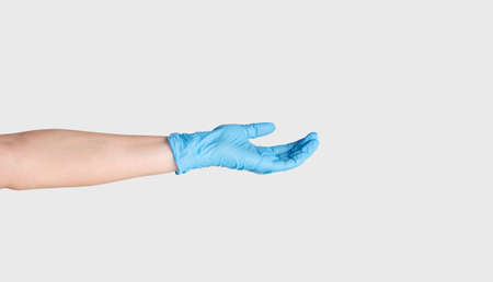 Concept of medical donation. Closeup of outstretched female hand in rubber glove on white...
