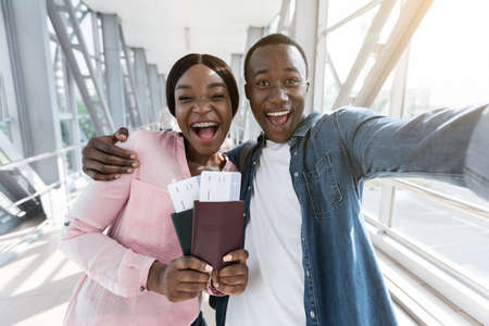Excited African Couple Taking Selfie At Airport With Passports And Tickets, Excited About Vacation Trip, Closeupの写真素材