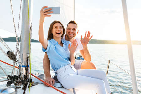 Couple On Yacht Making Selfie On Smartphone Enjoying Cruise Outdoors During Summer Vacation At...