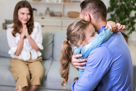 Daughters Love. Cheerful Wife Looking At Husband And Their Kid Girl Embracing At Home. Selective Focusの写真素材