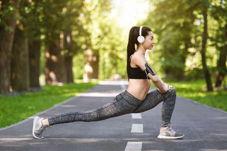 Fit Lifestyle. Sporty Asian Woman Exercising Outdoors In Park, Stretching Leg Muscles, Side View...