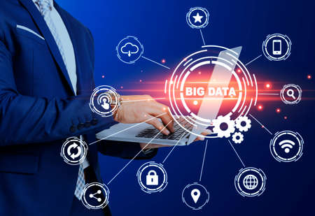 Modern technologies concept. Businessman using laptop and big data pictograms on trnsparent screen. Collageの写真素材