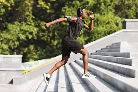 Sport Motivation. Black Male Athlete Running Up On Urban Stairs Outdoors, Enjoying Morning Workout,...