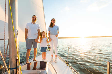 Weekend On Yacht. Parents And Kid Girl Standing On Boat Deck Holding Hands Sailing In Sea. Free Space For Textの写真素材