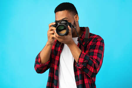 Photography Concept. African American Photographer Man Taking Photo Standing On Blue Background In...