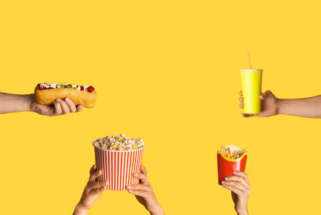 Collage with male hands holding various junk foods and drink on orange background, blank spaceの写真素材