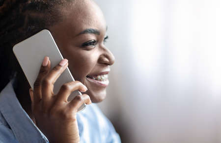 Mobile Communication. Closeup portrait of smiling black woman talking on cellphone, enjoying...