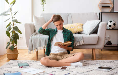 School guy reading books at home, got confused, copy space