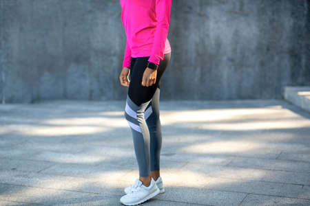 Sexy legs of black athletic lady jogging at public park, copy space