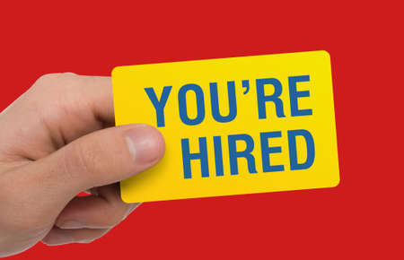 Headhunter showing card with phrase YOURE HIRED on red background, creative collage