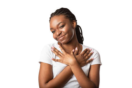 Gratitude. Thankful Black Girl Pressing Hands To Chest Standing On White Background, Smiling To...