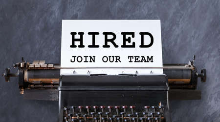 Career and employment concept. Phrase HIRED, JOIN OUR TEAM on paper sheet in vintage typewriter,...