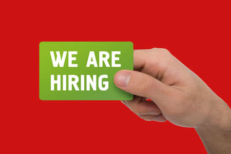 HR manager holding business card with words WE ARE HIRING over red background, collage