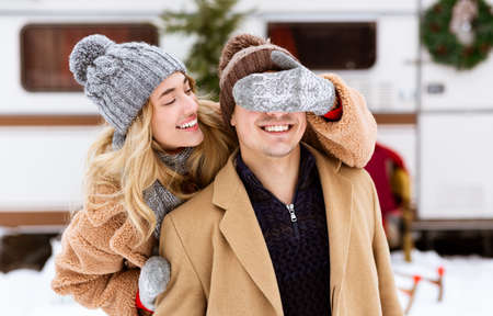 Romantic Millennial Couple Having Fun Outdoors On Winter Day, Loving Woman Covering Eyes To Boyfriend, Making Surprise, Closeupの写真素材