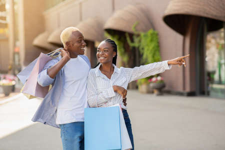 Beautiful young african american couple enjoying shopping and see new branding boutique, outdoorの写真素材