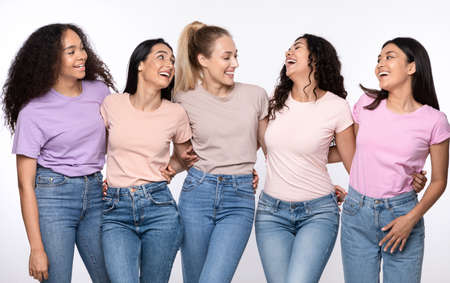 Group Of Happy Multiethnic Women Hugging Laughing Standing Together Over White Studio Background, Smiling Each Other. Female Friendship And Togetherness, Diversity And Unity Concept.の写真素材
